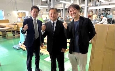 クライアントと担当者が工場で成果を喜ぶ様子